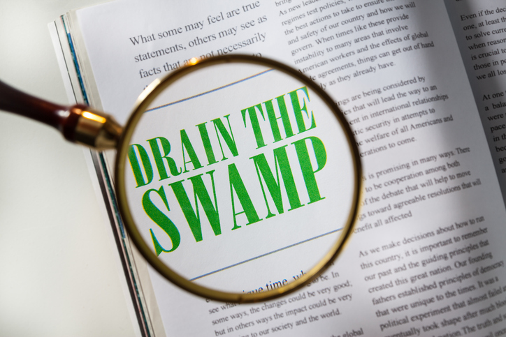 Magazine with article about Drain the Swamp with magnifying glass.